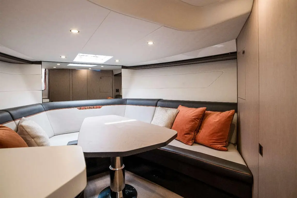 Stylish yacht interior featuring a seating area with textured cushions, a modern table, and soft lighting.